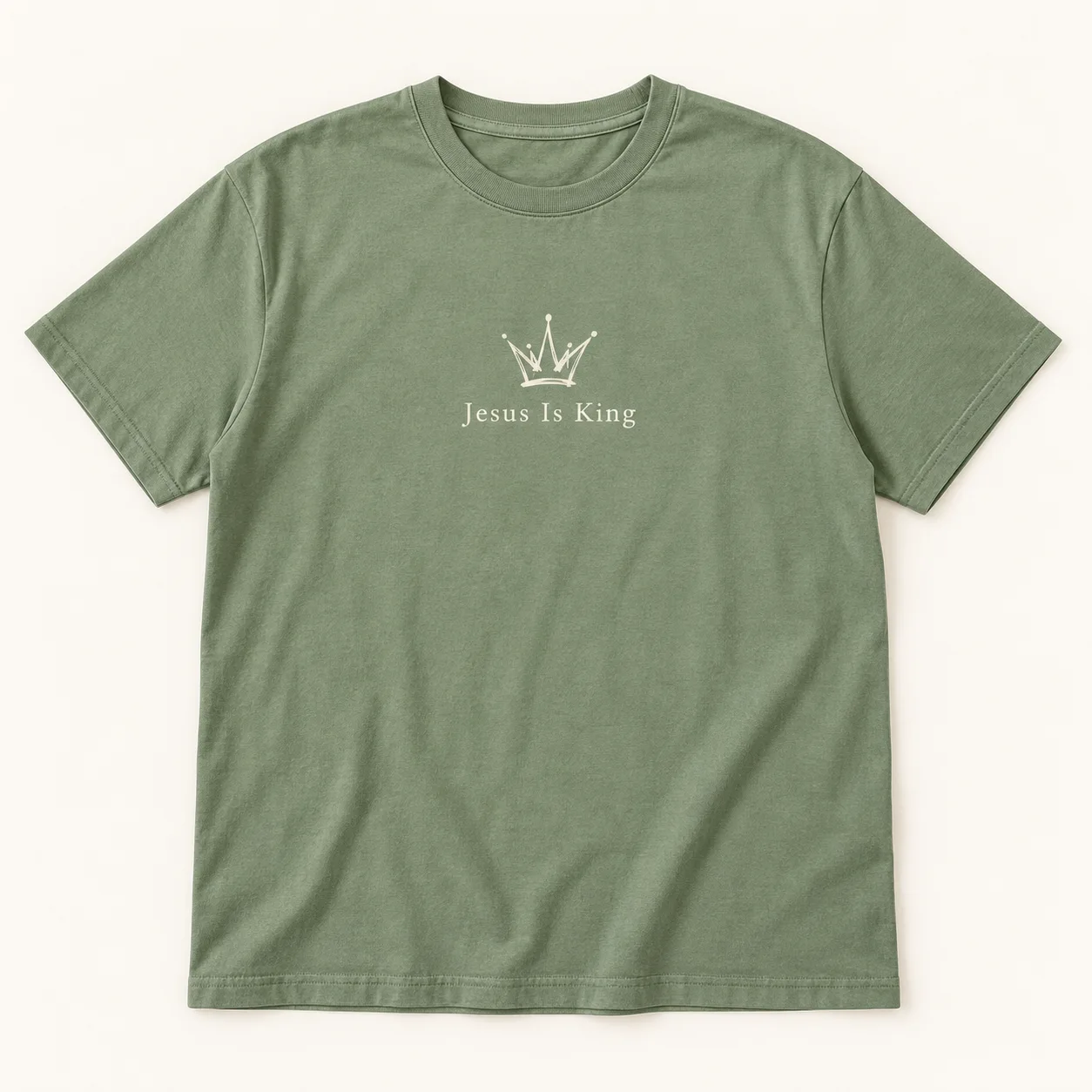 Jesus Is King Christian T-Shirt – Crown Graphic Tee – Design Preview Sage green Jesus Is King Christian T-shirt with a cream crown graphic